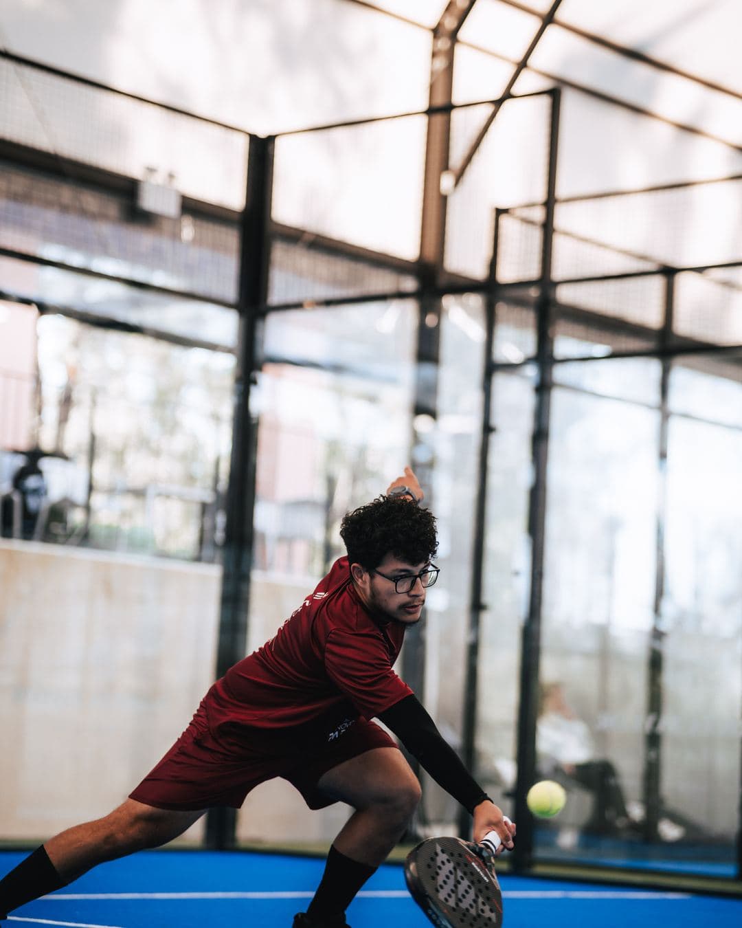 Padel player reaching for the ball